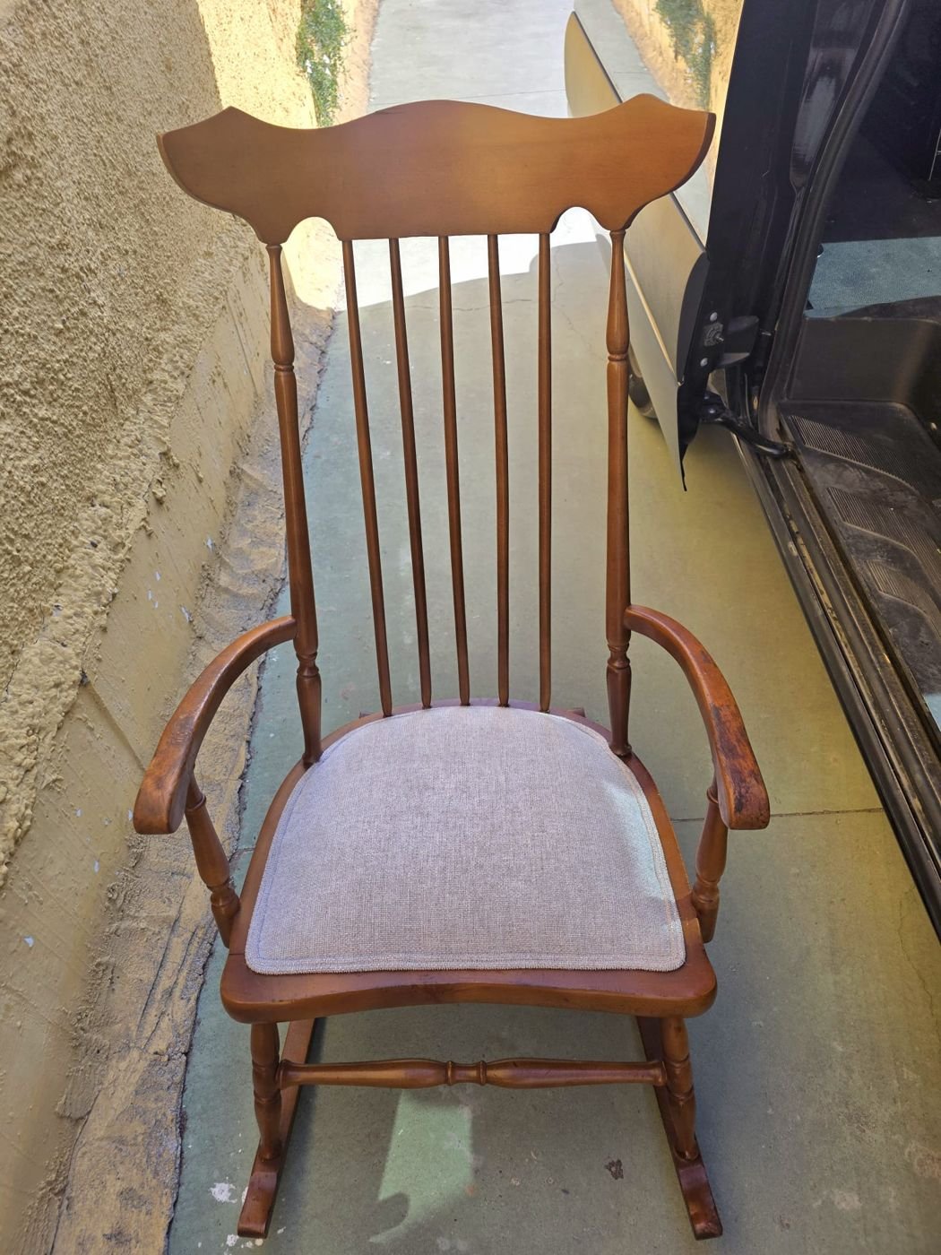 Mecedora de madera con asiento tapizado en gris